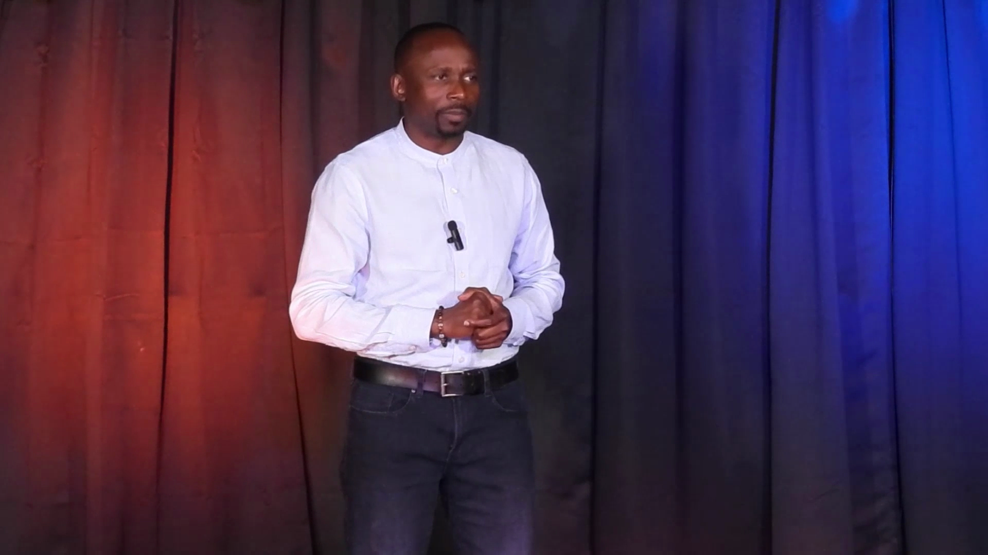 Amas on stage in white shirt and jeans